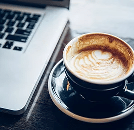 Coffee cup and computer to illustrate how outsourcing your SEO can help you relax knowing your website will soon rank well on Google.