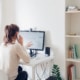 Shows a woman on the phone and looking at the computer. Represents seo services for therapists at Simplified will help support you with your counseling website