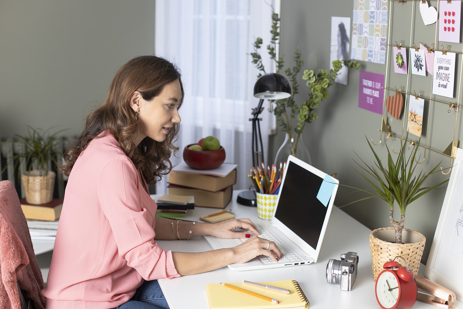 female therapist works in her at home office writing blogs after researching seo keywords that her ideal clients are looking for. She learns tips from members of the Simplified SEO consulting staff
