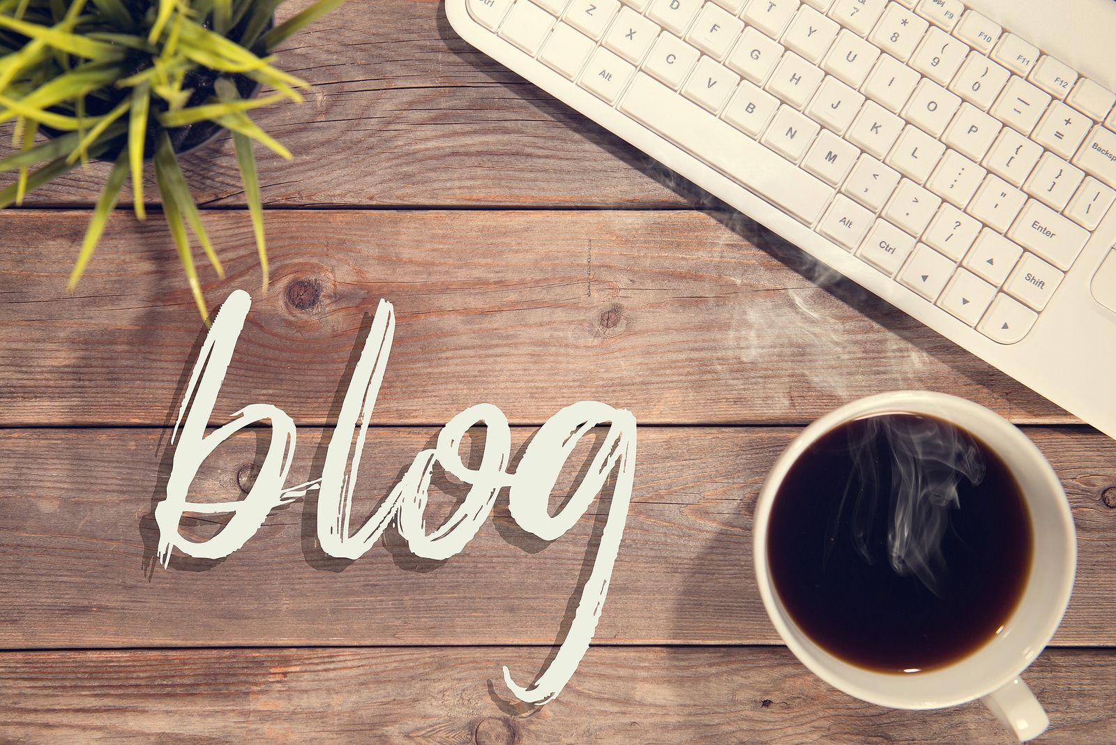 Blog text with computer keyboard, cup of coffee and plant pot. Represents the value of blogging for SEO when you are a speech therapist in private practice.