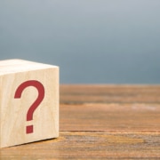 Image of a wooden block with a red question mark on its side. This image illustrates the many questions clients have about SEO, including "how long does SEO take?"
