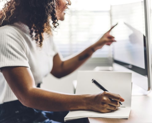 Image of a woman sitting at a desk representing the search for deal clients through simplified. | How to Build SEO for Therapists, How to rank on Google for Therapists, Is SEO Good for Therapists |