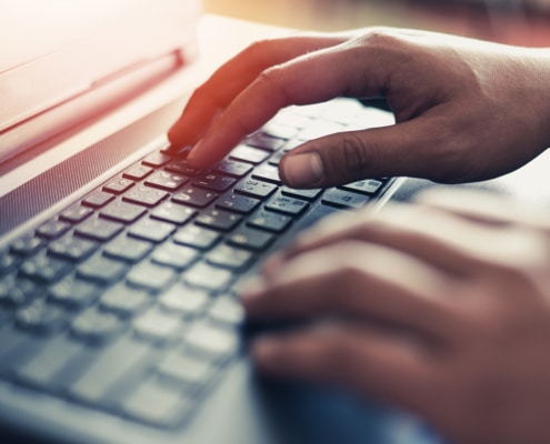 Hands on a computer representing a private practice owner fixing website mistakes to better their SEO. Learn tips on how to write a meta description for a counseling website and improve counselor SEO in Chicago, IL or Columbus, Oh.