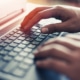 Hands on a computer representing a private practice owner fixing website mistakes to better their SEO. Learn tips on how to write a meta description for a counseling website and improve counselor SEO in Chicago, IL or Columbus, Oh.