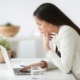 An Asian woman stands looking confused at her laptop. This could represent misunderstanding an off page SEO checklist. Learn more about on page and off page SEO, and how we can help with off page optimization.