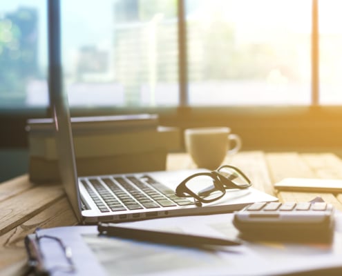 A set of glasses rest on a laptop as the morning sunlight pours through the window. This could represent SEO strategies for private practice owners. Contact Simplified SEO Consulting for DIY seo for small businesses.