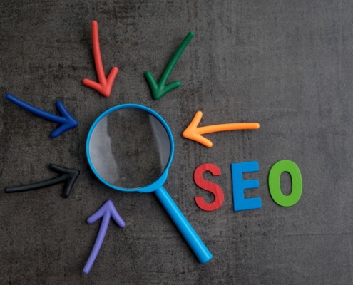 A magnifying glass with the text SEO and colorful arrows nearby. Simplified SEO offers search engine optimization for counselors. Learn more about counselor SEO, how to build SEO for therapists, and how we can offer support today!