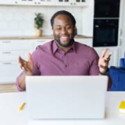 Happy man at his computer smiles as he meets with a group of therapists for a 12-week SEO mastermind with Simplified SEO Consulting