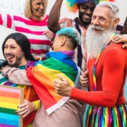 Happy people wearing gay pride flags celebrating the improvement of SEO keywords