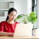 Photo of a woman using a computer at her desk representing the way therapists and counselors can add keywords to a counseling website through blogging to boost their SEO