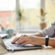 Photo of a woman typing on a computer representing the way therapists can use blogs and counseling service pages to improve their SEO and rank better on Google.