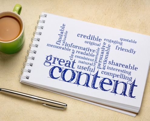 Photo of a notebook with a word cloud related to content representing the importance of writing blog posts and service pages on a mental health website that provide value for counseling and therapy clients.