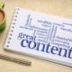 Photo of a notebook with a word cloud related to content representing the importance of writing blog posts and service pages on a mental health website that provide value for counseling and therapy clients.