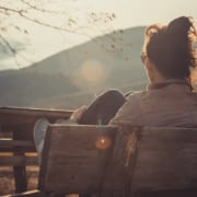 Photo of a young woman sitting outside at a park. This represents how writing local blogs about locations can boost your practice's SEO.