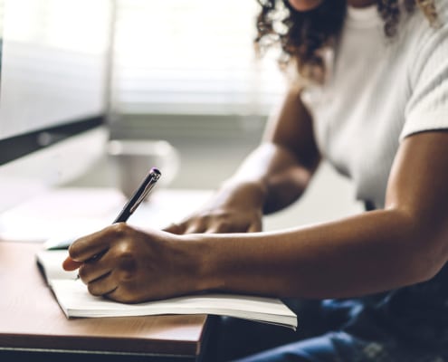 Shows a woman writing a blog for her private practice's website. Symbolizes how Simplified SEO Consulting can give mental health professionals seo private training to help with their SEO.