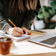 Shows an SEO copywriter taking notes. Represents how a copywriter can benefit seo coaching by supervising ChatGPT and the content it produces.