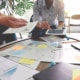 A group of people around a table talk with their hands and have papers laying on the table. Looking for SEO examples in healthcare to better understand it? Our team can help you grasp the concept of healthcare SEO and how to use it.