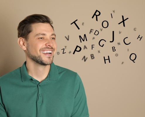 Man who looks like he's speaking with random letters coming our representing an adult with a speech or communication disorder requiring speech therapy.