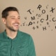 Man who looks like he's speaking with random letters coming our representing an adult with a speech or communication disorder requiring speech therapy.