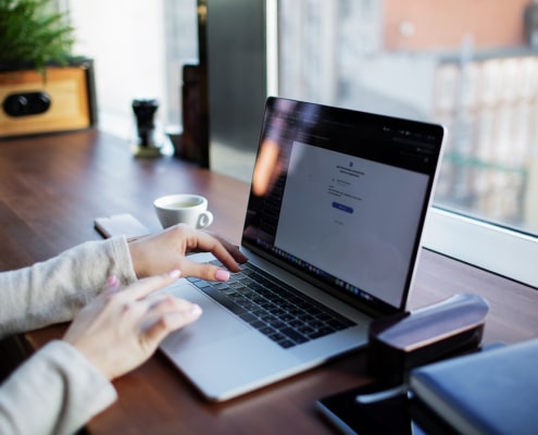 Close-up of hands typing on a laptop, representing the search for therapist directories. Learn more about the best therapist directories by searching for "therapist directory" today.