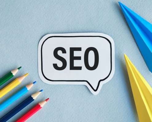 A close up of a text bubble that reads SEO next to pencils and paper airplanes. Learn tips on how to build SEO for therapists and the benefits of SEO for counselors. Learn more about private practice seo today.