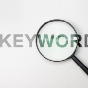 A magnifying glass on top of the word keyword. Trying to learn about what the best mental health therapy keywords are? Work with us to see how these help SEO.