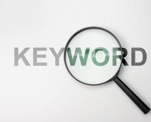 A magnifying glass on top of the word keyword. Trying to learn about what the best mental health therapy keywords are? Work with us to see how these help SEO.