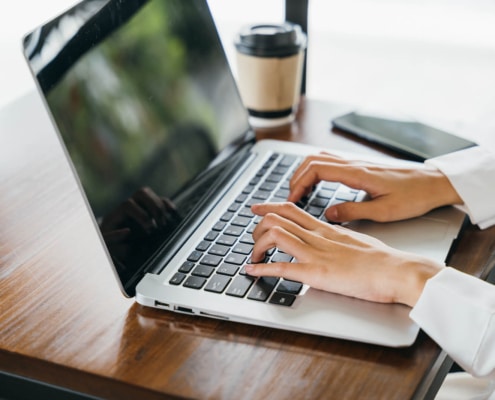 Woman typing on a laptop to create content for her private practice. Improve your Private practice SEO with ways to create content and begin using easy language for users to read without professional jargon.