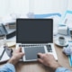 A person touching a tablet sitting on a laptop with papers on a desk. Searching for how you can improve your SEO in healthcare? We can teach you how to make SEO for the healthcare industry benefit you.
