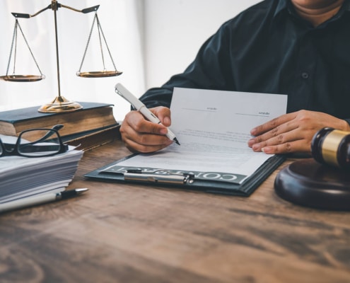 A scale of justice sitting on a desk. Curious to know the best law firm marketing strategies? Learn more here!