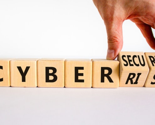 Cyber Risk on wooden blocks. If you are interested in learning more about password protection and scams, contact us today!