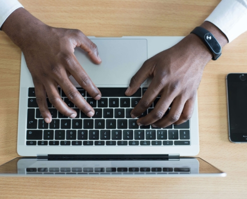 A man typing on a laptop. Representing how you can work on SEO & increase organic traffic on your own. Begin the SEO journey today.