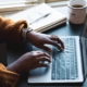 Shows a pair of black hands typing on their laptop to implement therapist SEO. Represents how counselor seo can be enhanced with AI assisted writing.