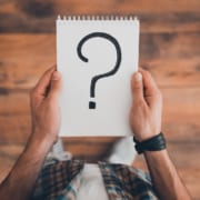 A man holding a notebook with a large question mark. With an SEO specialist optimizing your site, you can reach ideal clients & fill your caseload. Get started today.