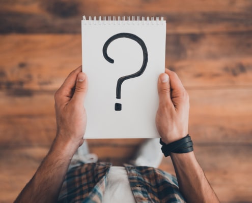 A man holding a notebook with a large question mark. With an SEO specialist optimizing your site, you can reach ideal clients & fill your caseload. Get started today.