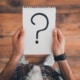 A man holding a notebook with a large question mark. With an SEO specialist optimizing your site, you can reach ideal clients & fill your caseload. Get started today.